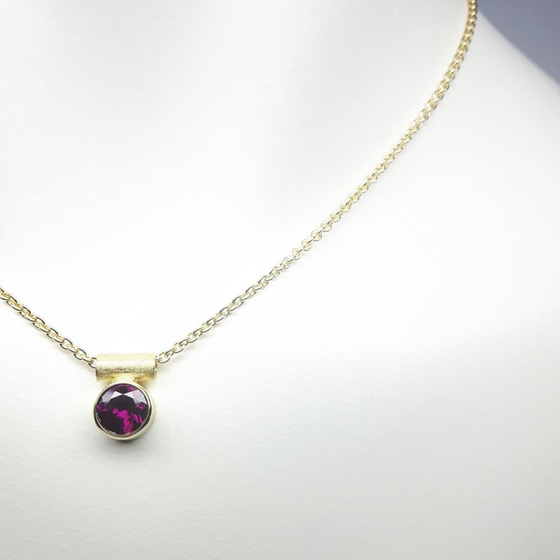 Pendentif en or jaune 18kt et grenat pourpre Ø7mm.