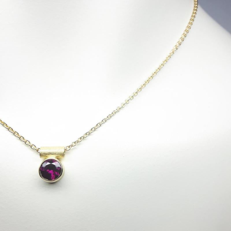 Pendentif en or jaune 18kt et grenat pourpre Ø7mm.